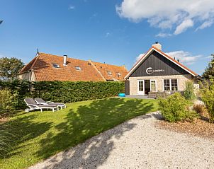 Ruime tuin bij Chill op Ameland vakantiehuis in Ballum met ligstoelen en terras.