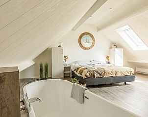 Lichte slaapkamer met bad in Chill op Ameland vakantiehuis, Ballum, Waddeneilanden.