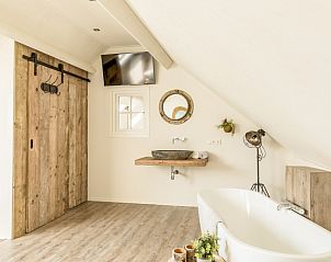 Stijlvolle badkamer met houten details in Chill op Ameland vakantiehuis, Ballum.