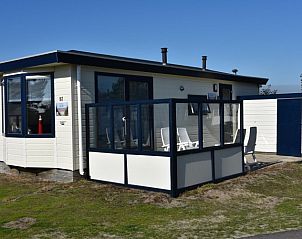 Buitenzijde van Oester 167 vakantiehuis, Ballum, Ameland met zonnig terras en moderne architectuur.