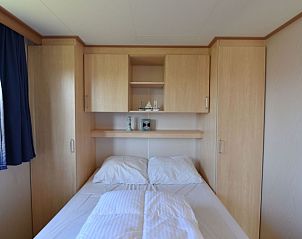 Knusse slaapkamer in Oester 167 vakantiehuis, Ballum, Ameland met tweepersoonsbed en ingebouwde kasten.