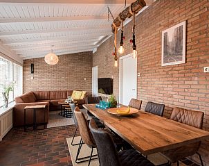 Gerumiges Esszimmer im Ferienhaus Artemis in Ballum, Ameland, mit Holztisch und moderner Beleuchtung.