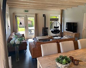Ruime eet- en zithoek in Skip Lodge, Ballum, Ameland met moderne inrichting en veel natuurlijk licht, ideaal voor een vakantie op de Waddeneilanden.