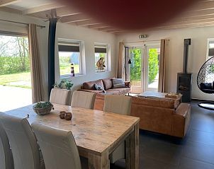 Lichte en open leefruimte in Skip Lodge, Ballum, Ameland met uitzicht op de tuin, perfect voor een ontspannen vakantie op de Waddeneilanden.