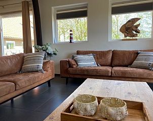 Comfortabele zithoek in Skip Lodge, Ballum, Ameland met stijlvolle decoratie en uitzicht op de natuur, ideaal voor een gezellige vakantie.