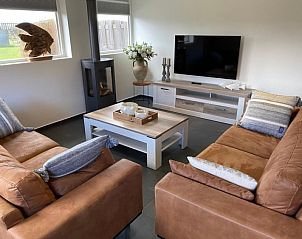 Moderne woonkamer van Tree Lodge, Ballum, Ameland met ruime sofa's en flatscreen-tv.