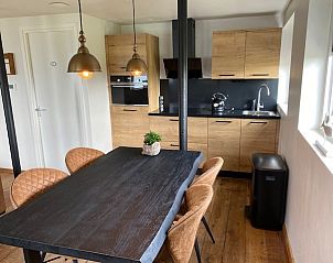 Modernes Esszimmer und Kche in Apartment Fleurie, Ballum, Ameland mit Holzmbeln und stimmungsvoller Beleuchtung.