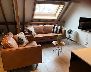 Moderne woonkamer van Petit appartement in Ballum, Ameland met een stijlvol interieur en uitzicht op de natuur.