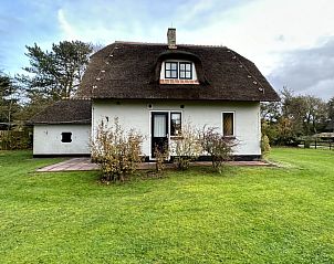 Rckansicht des Ferienhauses Akkerduin in Ballum, Ameland, mit Reetdach und grnem Garten auf den Watteninseln.