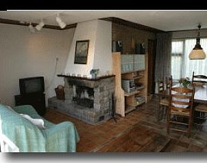 Cozy living room in vacation home Albatros, Ballum, with fireplace and dining area for a cozy atmosphere on Ameland.