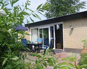 Zonnig terras van De Klipper vakantiehuis, Ameland met comfortabele stoelen en uitzicht op tuin.