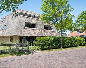 Straatbeeld van Waddenresidentie Ameland in Buren, Ameland, met traditionele architectuur en groene heggen.