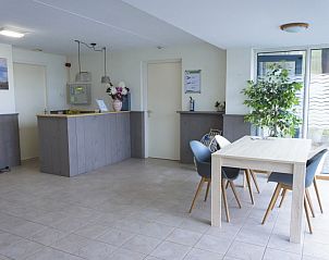 Lobby van Waddenresidentie Ameland in Buren, Ameland, met informatieve brochures en gezellige zithoek.