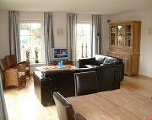 Cozy living room in Wervelwind vacation home, Nes, Ameland, with comfortable seating area and views of the Wadden Islands.