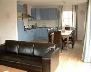 Modern kitchen and dining area in bungalow Wervelwind, Nes, Ameland, perfect for culinary evenings on the Wadden Islands.