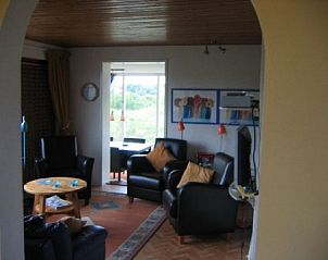 Interior of Markerwaard vacation home in Nes, Ameland with comfortable seating area, ideal for family gatherings on the Wadden Islands.