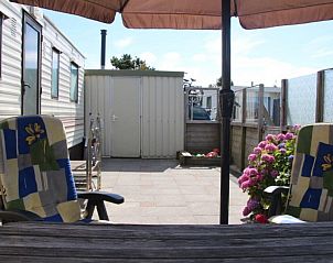 Zitgedeelte buiten bij stacaravan nr. 57, Buren, Ameland met uitzicht op tuin