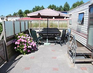 Privterras van stacaravan nr. 57 in Buren, Ameland met bloemen en schaduwplek