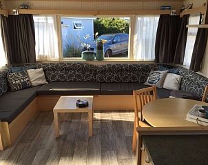 Gezellige zithoek in stacaravan De Hout, Buren, Ameland met veel lichtinval.