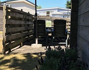Zonnig terras bij stacaravan De Hout, Buren, Ameland met parasol.