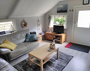 Gemtliches Wohnzimmer des Ferienhauses Poolster in Buren, Ameland mit bequemer Sitzecke und Tageslicht.