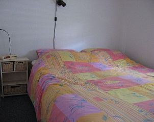 Gemtliches Schlafzimmer im Ferienhaus Poolster, Buren, Ameland, mit farbenfrohem Bettzeug und gemtlicher Atmosphre auf den Watteninseln.