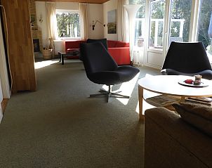 Lichte woonkamer in Oase vakantiehuis, Buren, Ameland met uitzicht op tuin.