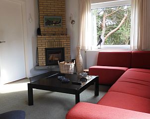 Lichte woonkamer met open haard in Oase vakantiehuis, Buren, Ameland.