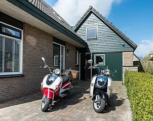 Entree van appartement Asterix in Buren, Ameland met scooters op de oprit voor een ontspannen vakantie op de Waddeneilanden.