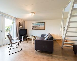Gezellige woonkamer van appartement Asterix in Buren, Ameland met moderne inrichting en uitzicht op de tuin.