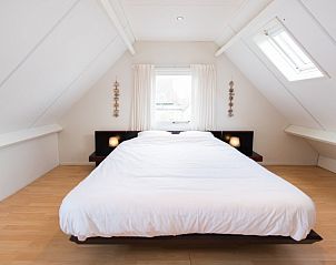Lichte slaapkamer in appartement Asterix, Buren, Ameland met groot bed en dakramen voor een rustgevende nachtrust.