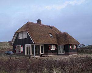 Roxboro vakantiehuis met rieten dak in Buren, Ameland, omringd door duinen.