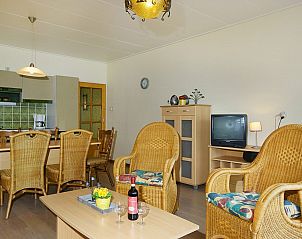 Gemtliches Wohnzimmer im Ferienhaus West, Buren, Ameland mit Korbsesseln und Landhauskche fr einen entspannten Aufenthalt.