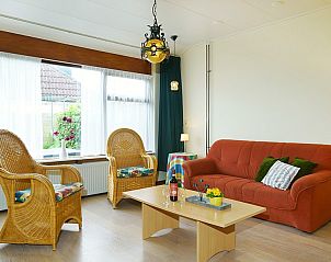 Gemtliches Wohnzimmer im Ferienhaus West, Buren, Ameland. Gemtliche Sitzecke mit Korbsesseln und Blick auf den Garten.
