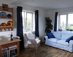 Gezellige woonkamer van Vakantiehuisje in Hollum op Ameland met comfortabele meubels en uitzicht op de natuur.