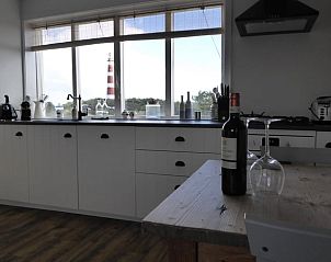 Keuken in Vakantiehuisje in Hollum op Ameland met uitzicht op de vuurtoren, perfect voor kookliefhebbers.