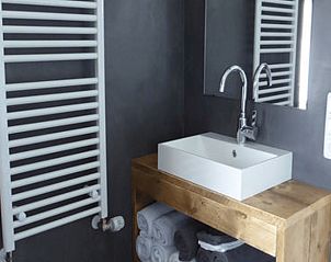 Elegante wastafel in Vakantiehuisje in Hollum op Ameland, met praktische opbergruimte en een moderne uitstraling.