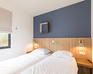 Sfeervolle slaapkamer in Kooikers Comfort vakantiehuis, Hollum Ameland, met moderne inrichting en comfortabele bedden voor een ontspannen verblijf.