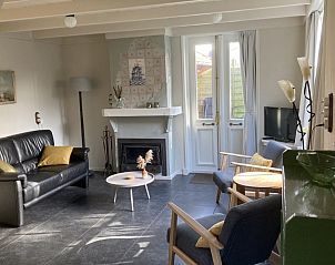 Ruime woonkamer met open haard in Beppe van Ameland vakantiehuis, Ameland.