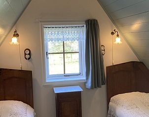 Knusse slaapkamer met twee bedden in Beppe van Ameland vakantiehuis, Waddeneilanden.