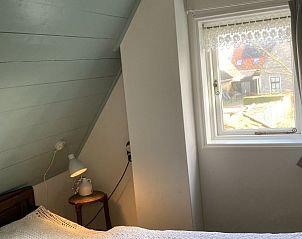 Slaapkamer met uitzicht in Beppe van Ameland vakantiehuis, Ameland.
