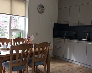 Eetkamer en keuken in Oerd vakantiehuis, Hollum, Ameland met grote ramen.