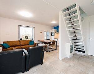 Ruime woonkamer met trap in vakantiehuis Onder de Pannen! in Hollum, Ameland.