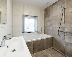 Stijlvolle badkamer met bad in vakantiehuis Onder de Pannen! op Ameland.