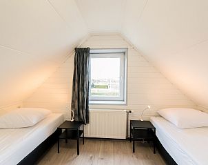 Knusse zolderkamer met twee bedden in vakantiehuis Onder de Pannen! in Hollum.
