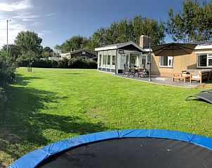 Spacious lawn with terrace at vacation home Strandloper in Hollum, Ameland, Wadden Islands.