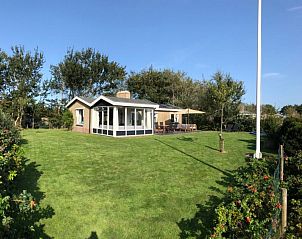 Sunny garden with flagpole at Strandloper vacation home, Hollum, Ameland.