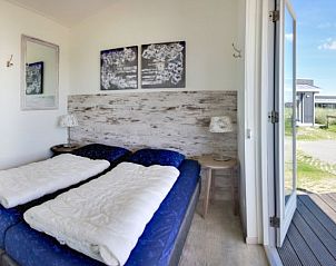 Schlafzimmer in Boomhiemke Huser, Hollum, Ameland mit Doppelbett und Blick auf die Terrasse.