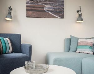 Cozy sitting area in VUURTORENLODGE 4, Hollum, Ameland with comfortable sofas and maritime decoration.
