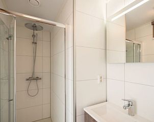 Modern bathroom in VUURTORENLODGE 4, vacation home in Hollum, Ameland with spacious shower and sleek finish.